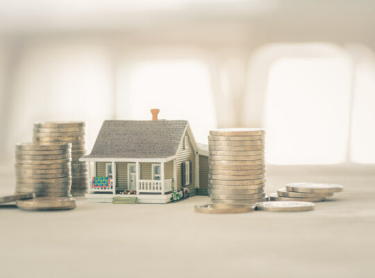 Haus zu verkaufen / Umkehrhypothek / Mietkaufvertrag, Finanzkonzept : Einstöckiges Modellhaus auf weißem Holzboden, zeigt, dass der Käufer ein luxuriöses Wohnobjekt kauft, um dort zu leben und für den eigenen Nutzen zu investieren