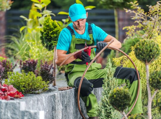 Eine Person baut ein Bewässerungssystem in ein Garten ein