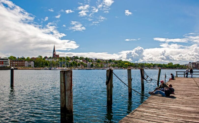 Veranstaltungen Flensburg – Menschen entspannen am Hafen bei sonnigem Wetter