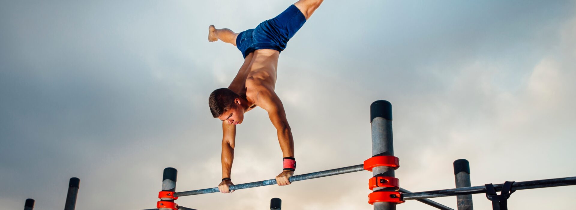 Calisthenics Training an einer Outdoor-Stange bei Sonnenaufgang am Strand