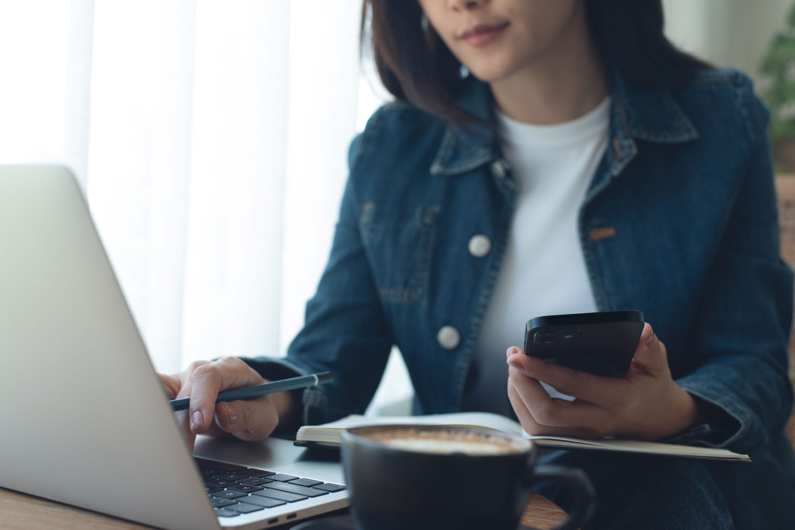 Eine Person sitzt vor ihrem Laptop an einem Tisch und lernt