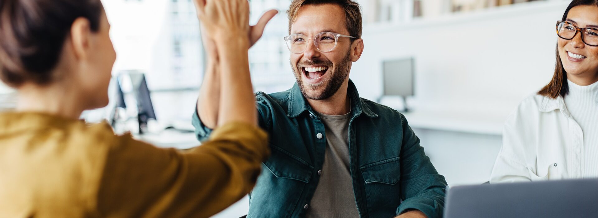 Team feiert Erfolg mit High-Five | Amazon Full Service Agentur
