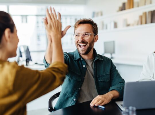 Team feiert Erfolg mit High-Five | Amazon Full Service Agentur