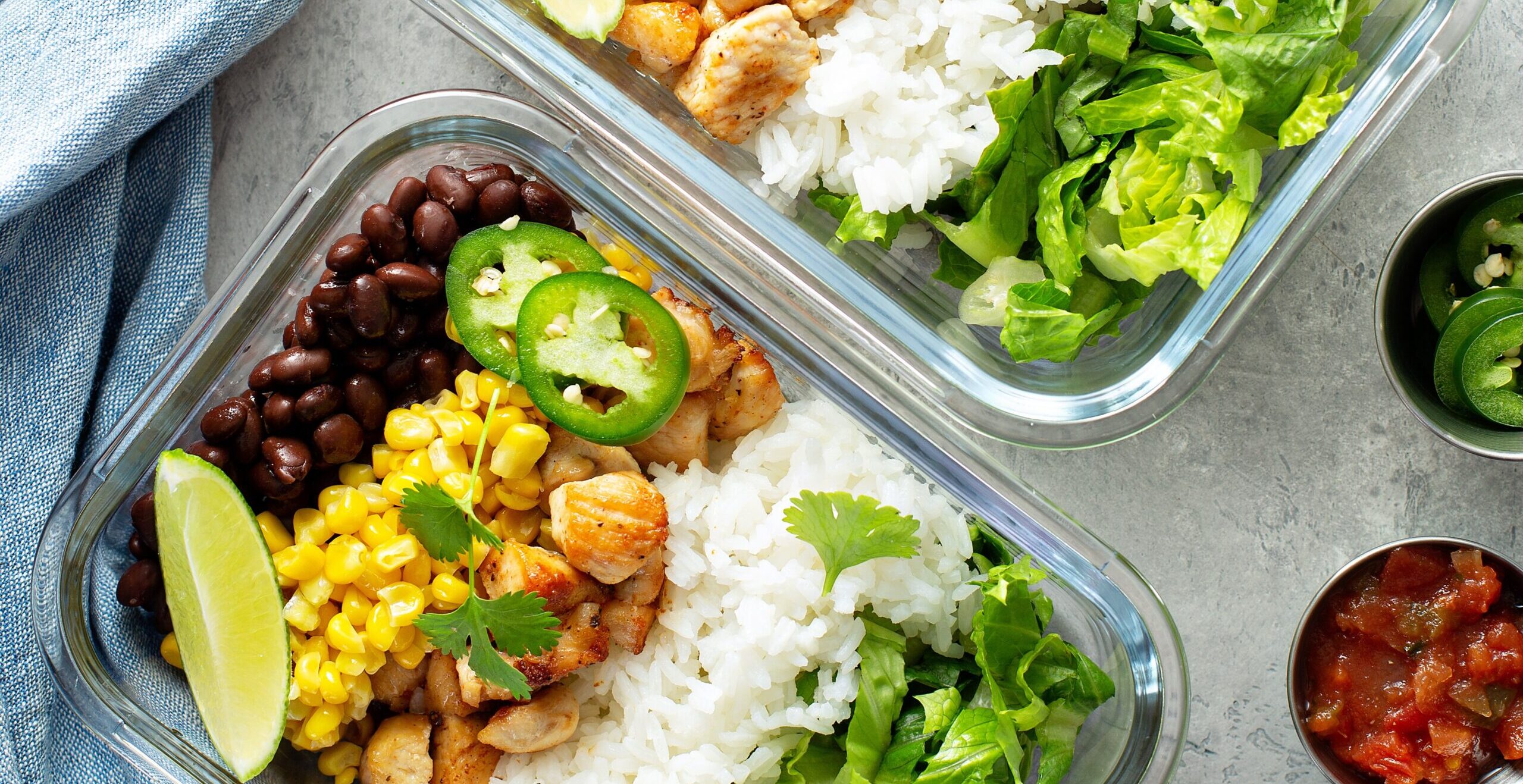 Gesunde grüne, von Mexiko inspirierte Mahlzeitvorbereitung mit Huhn, Reis, Bohnen, Mais, Salat